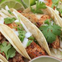 Chipotle Lime Fish Tacos · Three tacos made with Tilapia sautéed in adobo lime seasoning, and topped with shredded cabb...