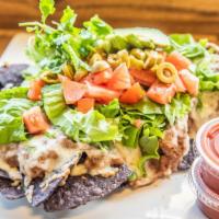 Botana · Blue corn tortilla chips topped with pinto beans, green pepper, tomato, green olives and red...