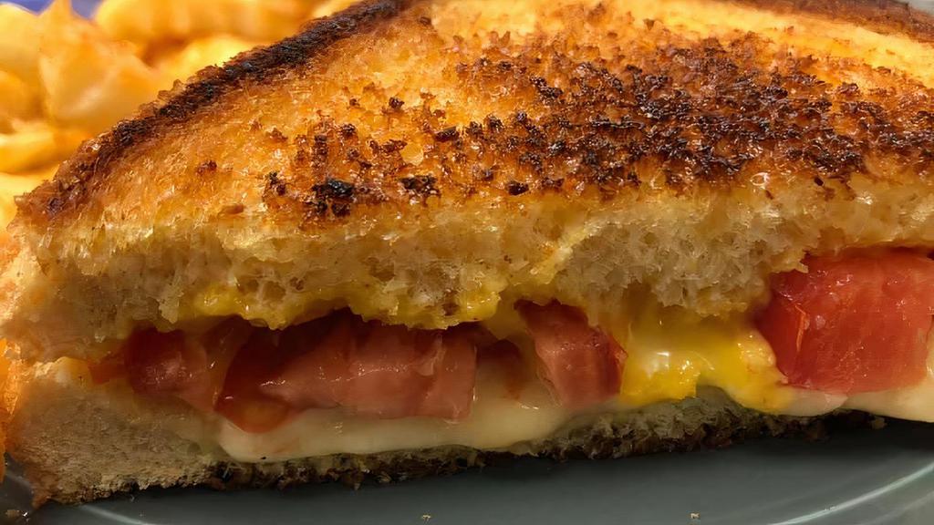 Grilled Cheese For Grown Ups · American & Danish Havarti cheeses buttery grilled on tall egg bread. Served with a hand sliced tomato and chips.