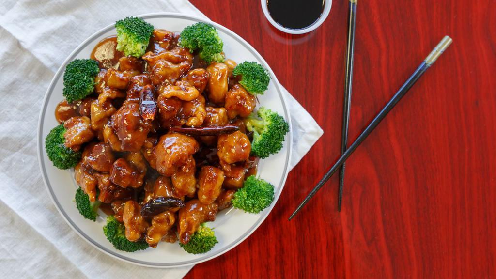General T'So Chicken · Chunks of  battered chicken deep fried then smothered in spicy General T'so sauce and roasted red   chilli pepper on a bed of  broccoli.