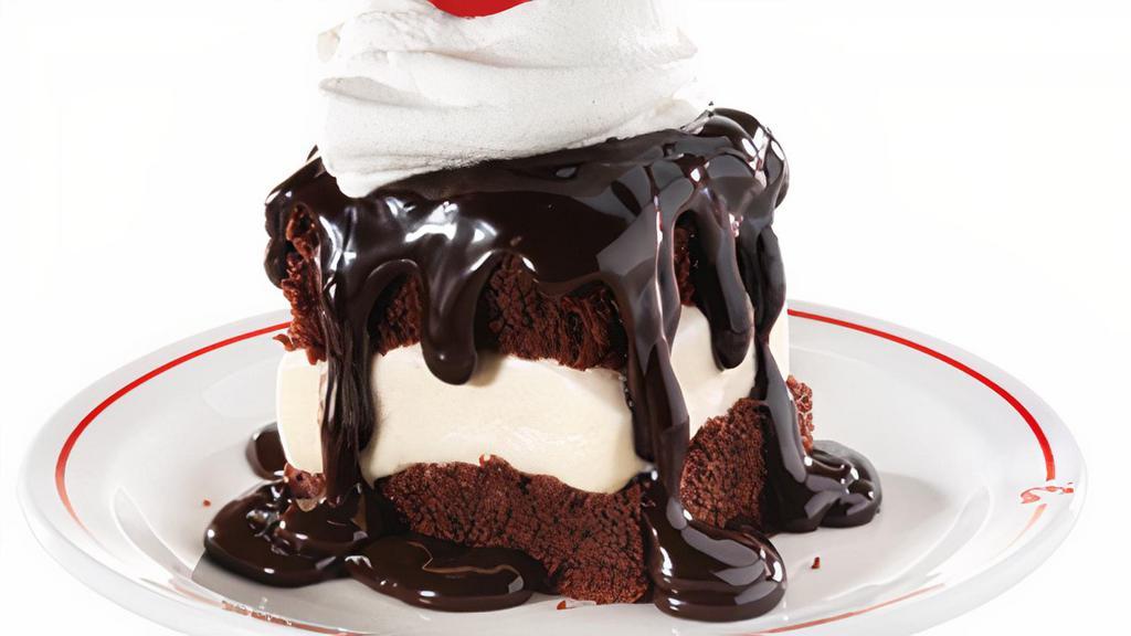 Hot Fudge Cake · Vanilla ice cream sandwiched between two fudge cakes, smothered with hot fudge and topped with whipped topping and a cherry.