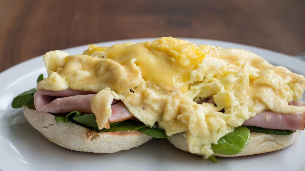 Eggs Benedict · Made with soft scrambled truffle eggs, ham, spinach and tangy hollandaise on an English muffin.