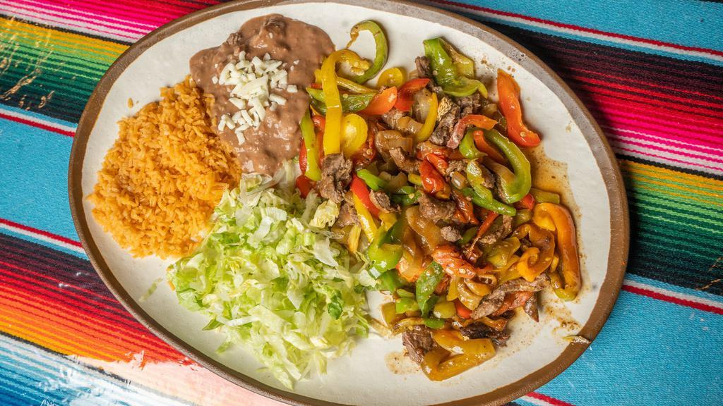Fajitas Dinner · Fajitas served with bell pepper, tomatoes, onion, rice and beans and tortillas.