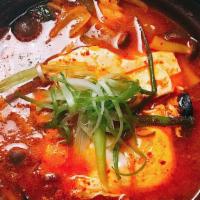 Soft Tofu Stew · Spicy stew cooked with squid, shrimp, silken tofu, zucchini, and onions with a drop of raw e...