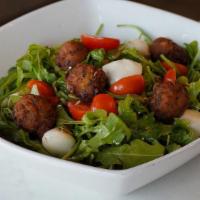 Heirloom · Arugula, heirloom tomatoes, mozzarella, mini veggie balls, pesto vinaigrette.