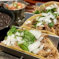 Tacos De Carnitas · Tender pork tips in three soft corn tortillas with onions, and cilantro. Tomatillo salsa, bl...