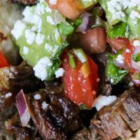 Carne Asada · Wood grilled steak drizzled with avocado-tomatillo salsa topped with pico de gallo & queso f...