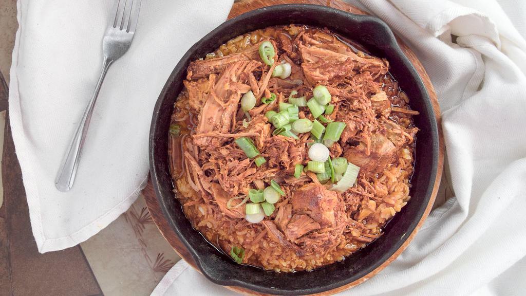 Cochinita Pibil · Marinated baked pork Yucatan style. Served on a bed of rice, and sprinkled with fresh green onions. Served with three flour tortillas, beans, lettuce, guacamole, sour cream, pico de gallo, and tomato.