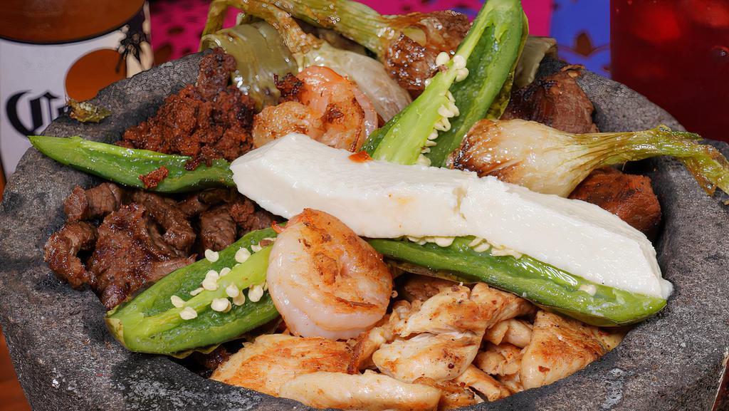 Molcajete · Our tender steak, grilled chicken, shrimp, pork and chorizo served on a Mexican stone garnish with cactus, queso fresco and cambray onions. Served with rice and beans.