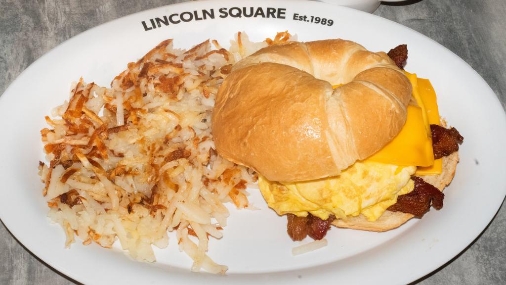 Breakfast Croissant · Two scrambled eggs on a grilled croissant finished with melted cheese, served with hash browns & your choice of ham, sausage or bacon.