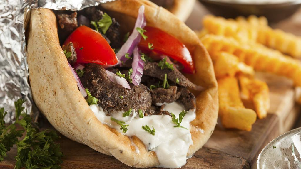 Greek Gyro Pita · A traditional Greek delight of gyro meat, sliced onions & tomatoes served on a warm pita with our signature cucumber sauce.