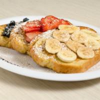 Tour De Fruit · Golden brown French toast topped with a delicious assortment of fresh strawberries, bananas ...