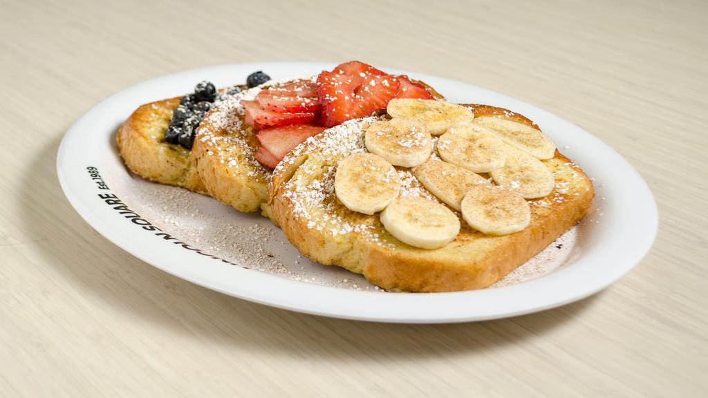 Tour De Fruit · Golden brown French toast topped with a delicious assortment of fresh strawberries, bananas & blueberries, topped with our homemade cinnamon whipped butter.