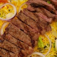 Steak Salad · Served over romaine lettuce with tomato, onion, boiled egg, and shredded cheese with pita br...