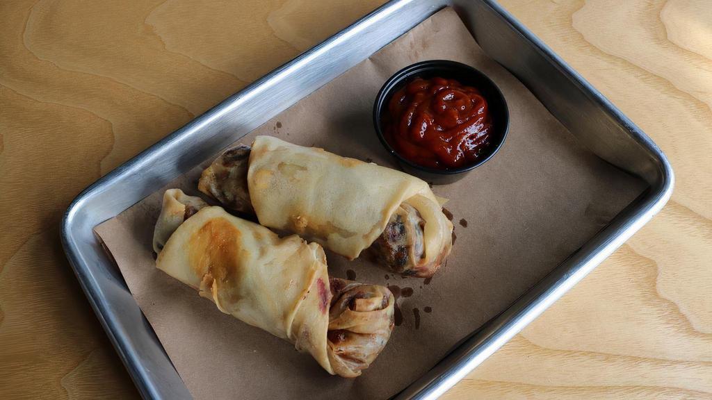 Vegan Egg Rolls · Filled with chili-spiced black beans, cabbage, carrots, corn, rice noodle, green onion, and roasted garlic. Served with bourbon barbeque sauce and sweet ginger chili sauce.