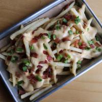 Queso Fries · Loaded with bacon, chives, and house queso.