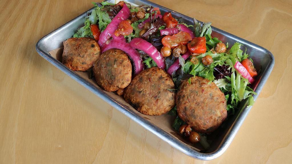 Vegan Falafel Salad · Spring mix blend with cilantro, mint, and parsley. Lemon-mint vinaigrette. Handmade falafel. Crispy garbanzo beans. Pink pickled onions. Blistered mint-infused cherry tomatoes.