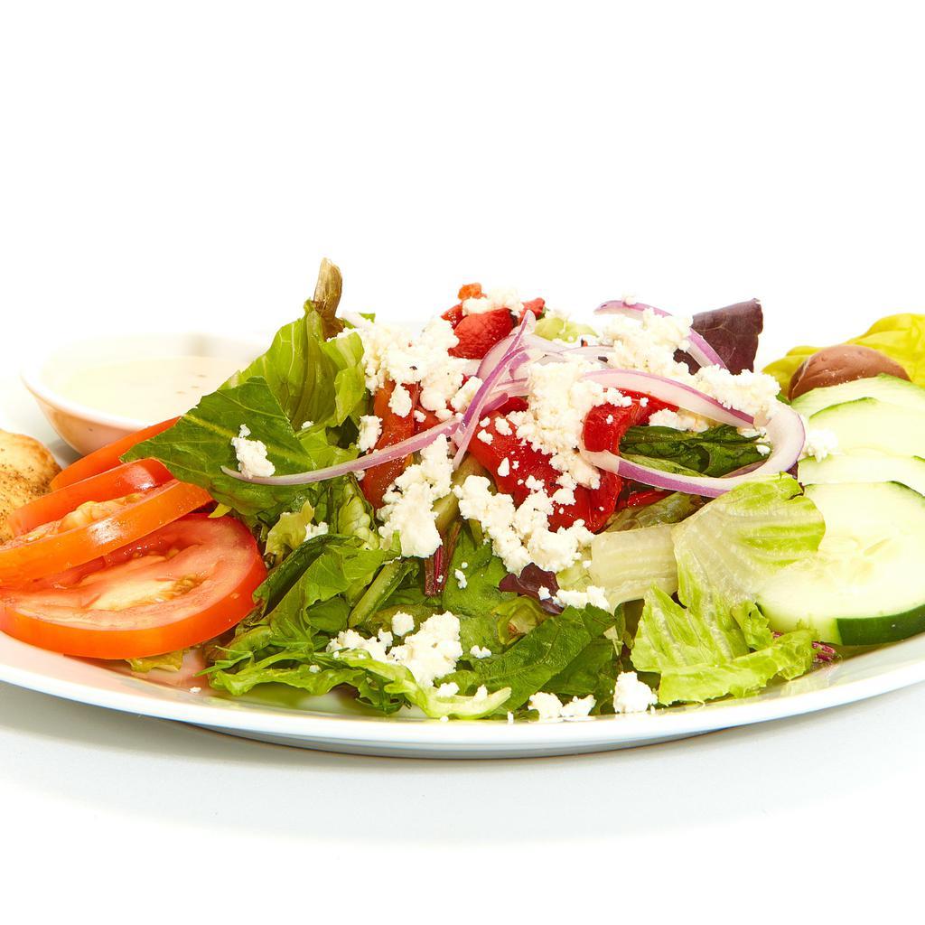 Greek Salad · Fresh mixed lettuces, tomatoes, cucumbers, roasted red peppers, red onions, feta, pepperoncini, Kalamata olives, a Baked Pita Chip, and Greek dressing.