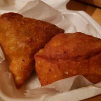 Beef Samosas · Two samosas filled with beef and wrapped in a light pastry.