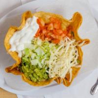 Taco Salad · A taco shell acting as a bowl for beans, lettuce, tomato, cheese, sour cream, 
 and guacamole.