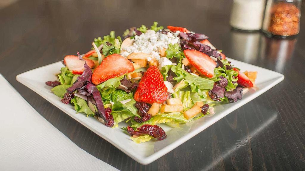 Harvest Salad · Gluten friendly. Fresh greens, cubed apples, bleu cheese crumbles, craisins, toasted almonds, and sliced strawberries, tossed with our homemade harvest vinaigrette dressing.
