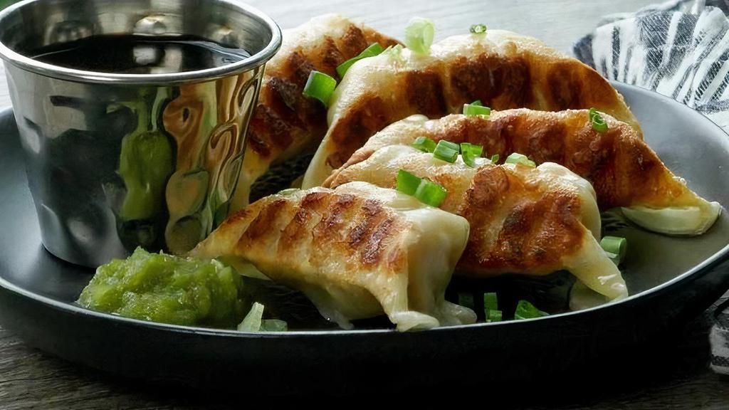 Chicken Gyoza · Pan-fried chicken and vegetable dumplings served with yuzu kosho and a soy dipping sauce.
