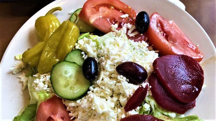 Greek Salad · Our Greek salad is specially prepared with chopped fresh lettuce, tomatoes, cucumber slices, Feta cheese, Greek olives, beets, pepperoncini and our own home-made Greek dressing.