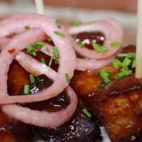 Bbq Belly Bites · Roasted pork belly tossed in Rooster's signature BBQ sauce and topped with pickled red onion