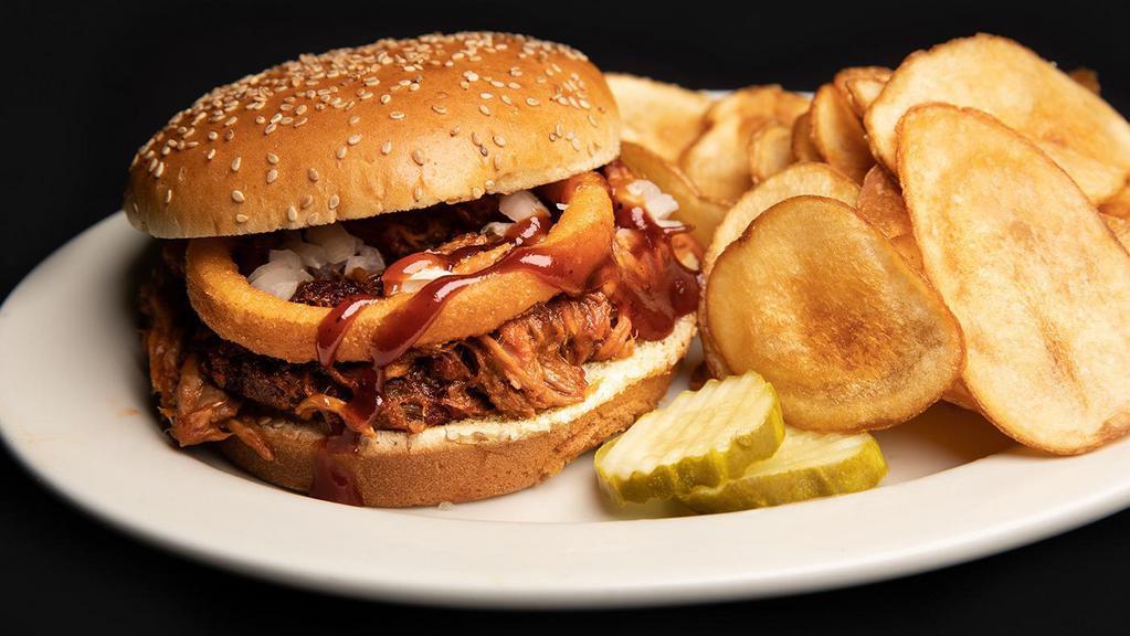 Pulled Pork Sandwich · Slow smoked, shredded pulled pork topped with BBQ sauce and an onion ring served on a sesame seed.