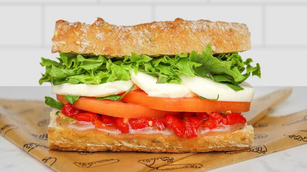 Caprese Sandwich · fresh mozzarella, vine-ripened plum tomato, roasted red peppers, basil + leafy greens on French bread