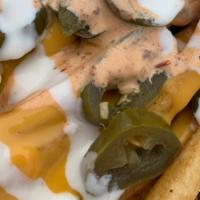 Nacho Fries · A bed of fries topped with nacho cheese, ranch, house cajun orange sauce and topped with Jal...