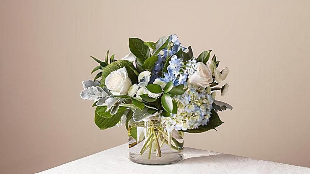Clear Skies Bouquet · Let this uplifting arrangement be reminders of the clear skies ahead. Capturing the feeling of hope that a new day brings, this bouquet is composed of voluminous hydrangea blooms and vibrant belladonna delphinium to refresh their mood. Vase included. Please Note: The bouquet pictured reflects our original design for this product. While we always try to follow the color palette, we may replace stems to deliver the freshest bouquet possible. Item # NFGS