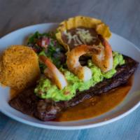 Mar Y Tierra · Our signature grilled 9 oz. outer skirt steak served over ranchero sauce and topped with gua...