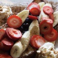 Fruit Explosion French Toast · Topped with strawberries, bananas, and blueberries.