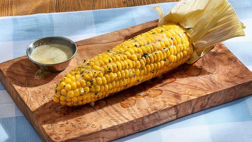 Fresh Corn-On-The-Cob (Premium Side) · Cooked in the husk and seasoned with garlic butter.