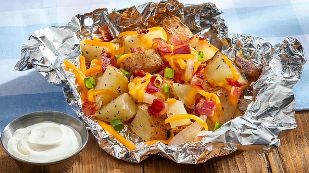 Campfire Potatoes (Premium Side) · Roasted potatoes topped with garlic butter, cheese, bacon and green onions wrapped in foil. Served with sour cream.