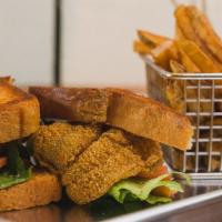Famous Fried Fish Sandwich · Perfectly seasoned fried catfish fillet topped with lettuce, tomato, and remoulade sauce on ...