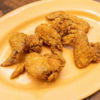 Famous Fried Chicken Wings · Five golden fried chicken wings.