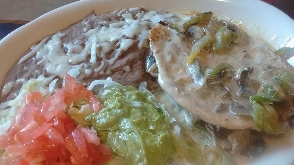 Pollo Del Carmen · Grilled chicken breast, cooked with chorizo and topped with cheese dip. Served with beans, guacamole salad & tortillas.