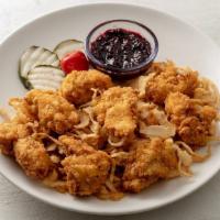 Hot Chicken Bites · Nashville-style hot chicken bites on a pile of haystack onions. Served with blackberry dippi...