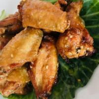 8 Piece Honey Garlic Chicken Wings · Cooked wings of a chicken coated in sauce or seasoning.
