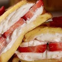 Stuffed Strawberry Cream Cheese French Toast · 3 slices of French Toast with strawberry cream cheese and topped with fresh strawberries