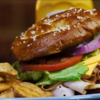 Twisted Turkey Sandwich · A soft pretzel bun with turkey breast, American cheese, lettuce, tomato, and onion. Served w...