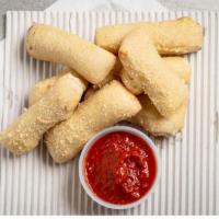 Inn Stix · Brushed with garlic butter and topped with parmesan cheese blend and served with a side of p...