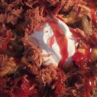 Pulled Pork Nachos · nacho chips covered in white queso nacho cheese topped with our famous pulled pork and your ...