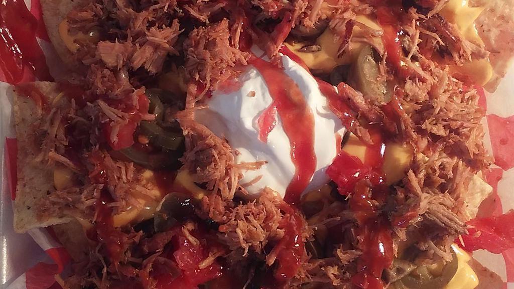 Pulled Pork Nachos · nacho chips covered in white queso nacho cheese topped with our famous pulled pork and your choice of our 4 barbecue sauces