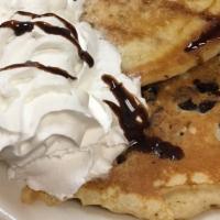 Chocolate Chip Pancakes · Topped with whipped cream and drizzled with chocolate syrup and powdered sugar.