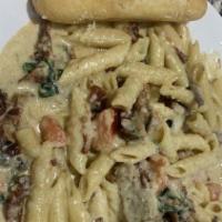Prime Rib Pasta · Tender prime rib, bacon, spinach, mushrooms, and sundried tomatoes with penne pasta in an al...