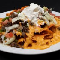 Beef Nachos · Nachos, beef, cheddar sauce, onions, green peppers, tomatoes, lettuce, sour cream