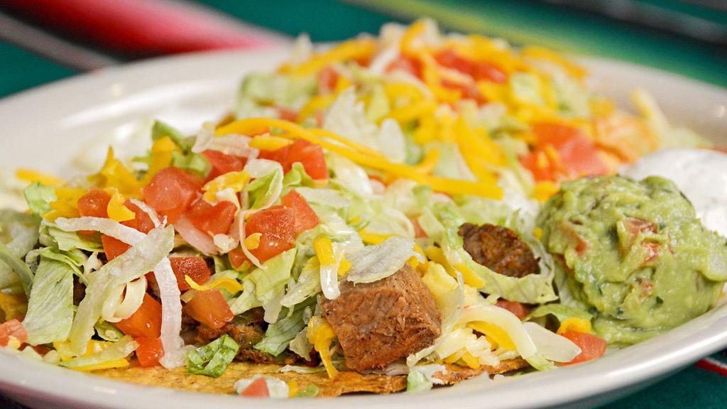 Tostada Plate · Two crisp fried corn tortillas with choice of meat topped with lettuce, diced tomatoes and cheddar and jack cheeses. Shredded chicken with rice, ground or shredded beef with beans or tender pork with beans. Served with sour cream and always-fresh guacamole.
